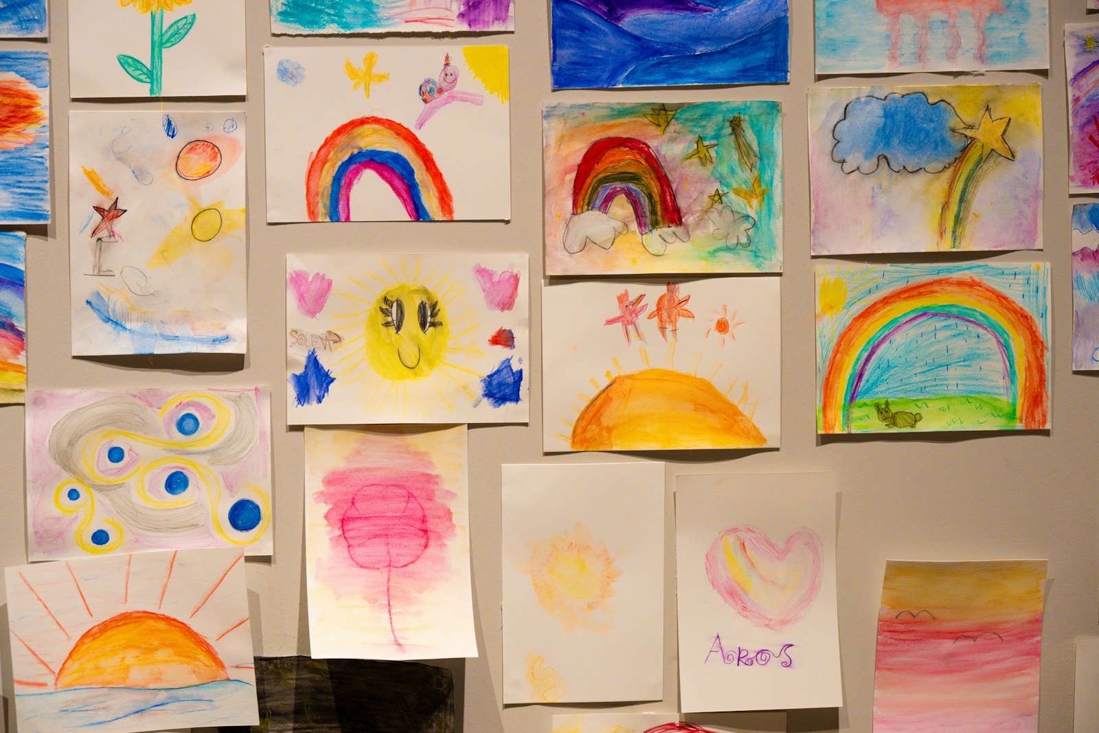 A wall of children's rainbow paintings